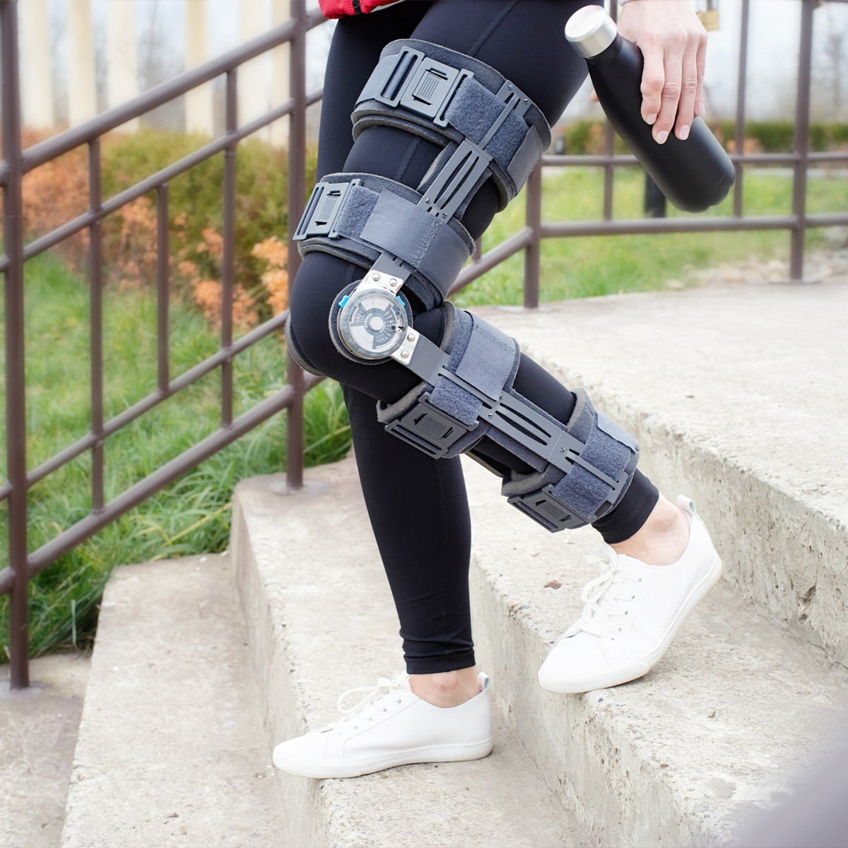 Woman with a knee brace walking down stairs